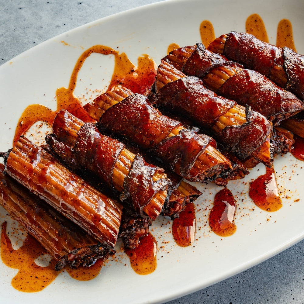 Smoked barbecue shotgun shells plated and drizzled with barbecue sauce
