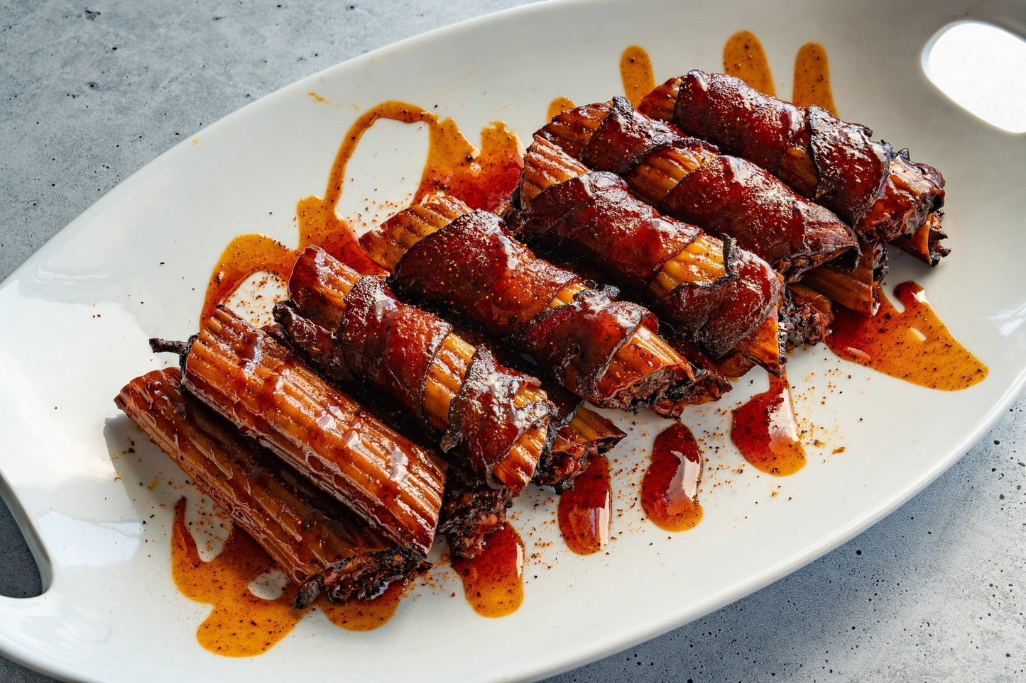 Smoked barbecue shotgun shells plated and drizzled with barbecue sauce